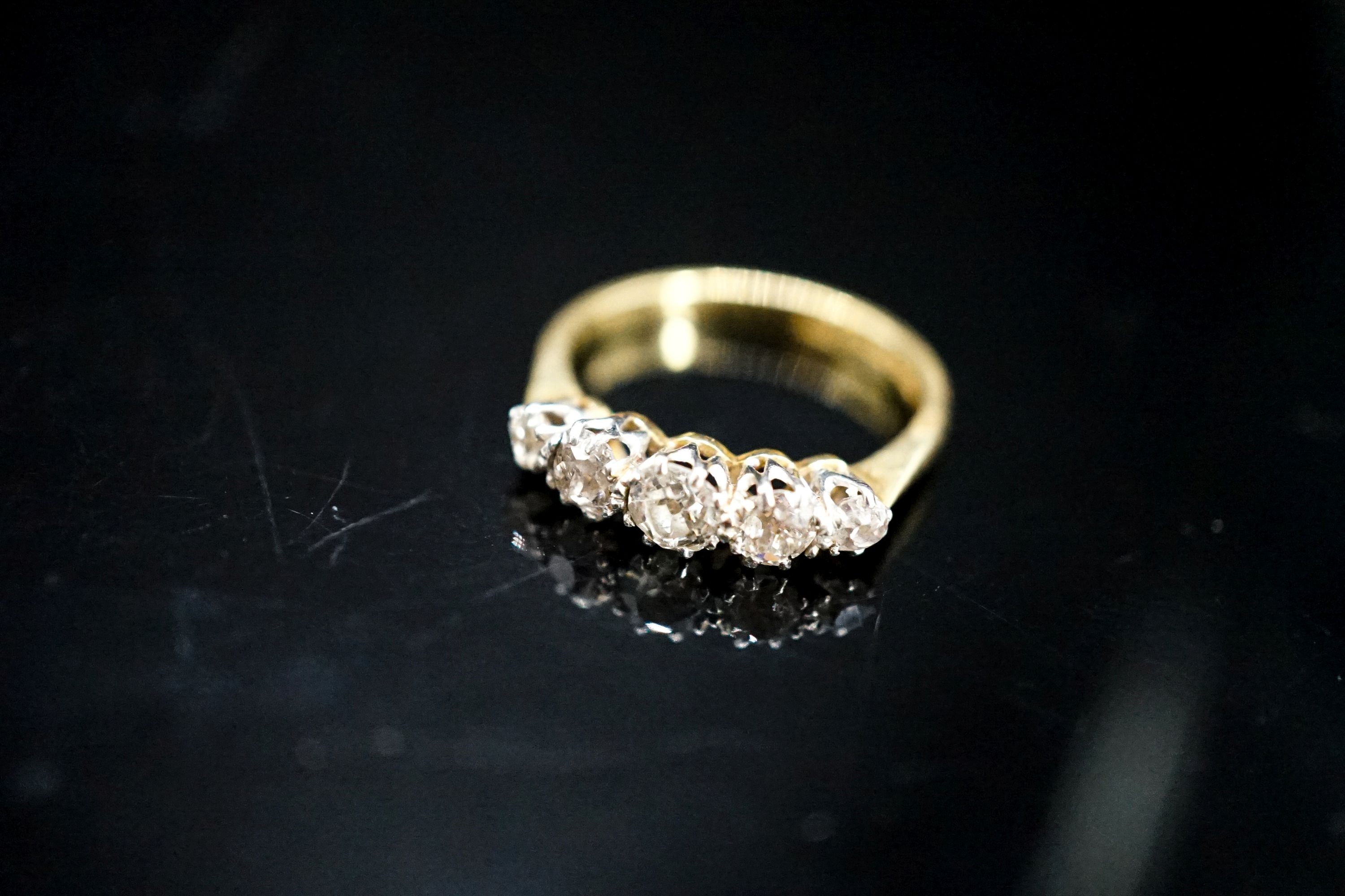 An 18ct, plat and graduated five stone diamond set half hoop ring, size N, gross 3.1 grams.